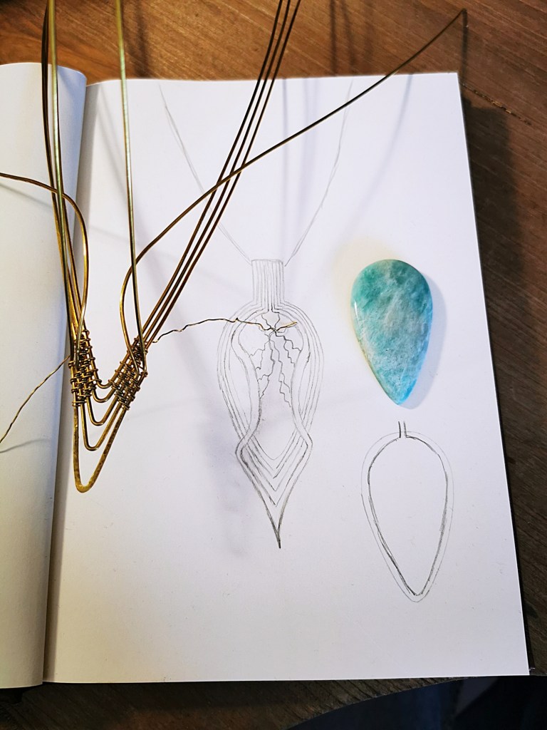 Geste du wire wrapping — tissage de fil métallique autour d'une pierre naturelle